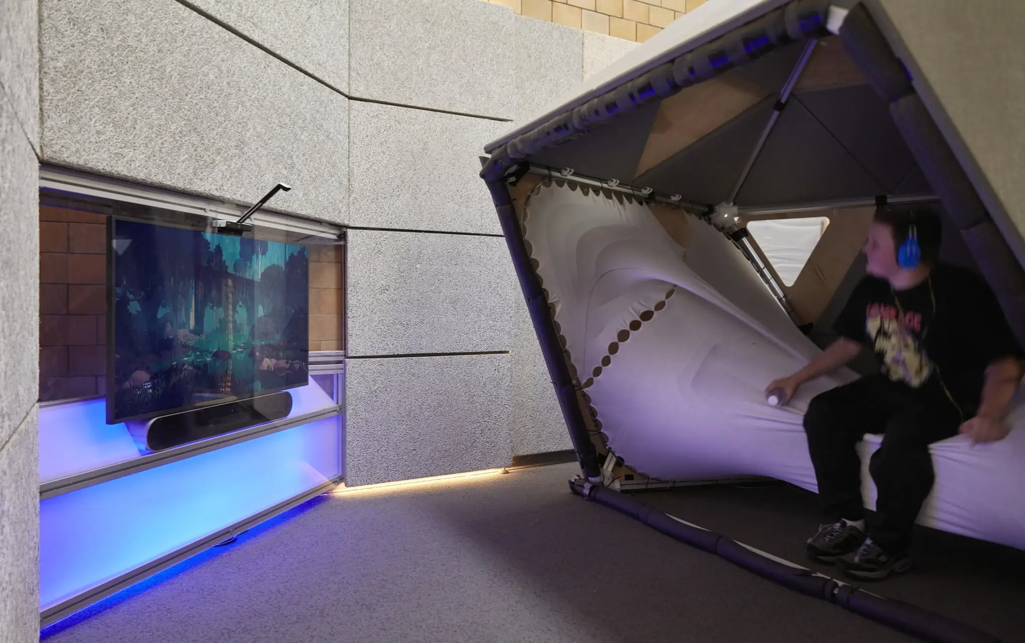 A student in the cocoon of the Lane Tech sensory hub, beside the Ouva media wall