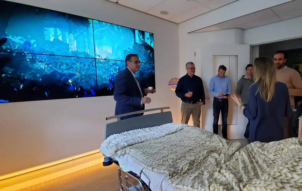 Clinicians and Ouva’s designers in a patient room at Radboud University Medical Center, the room’s Ouva wall beside them